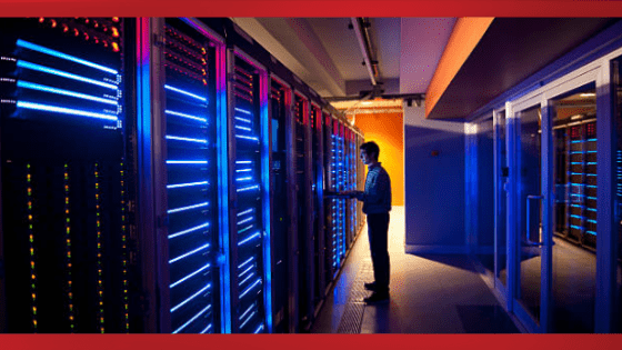 a person in a dark server room working on glowing servers
