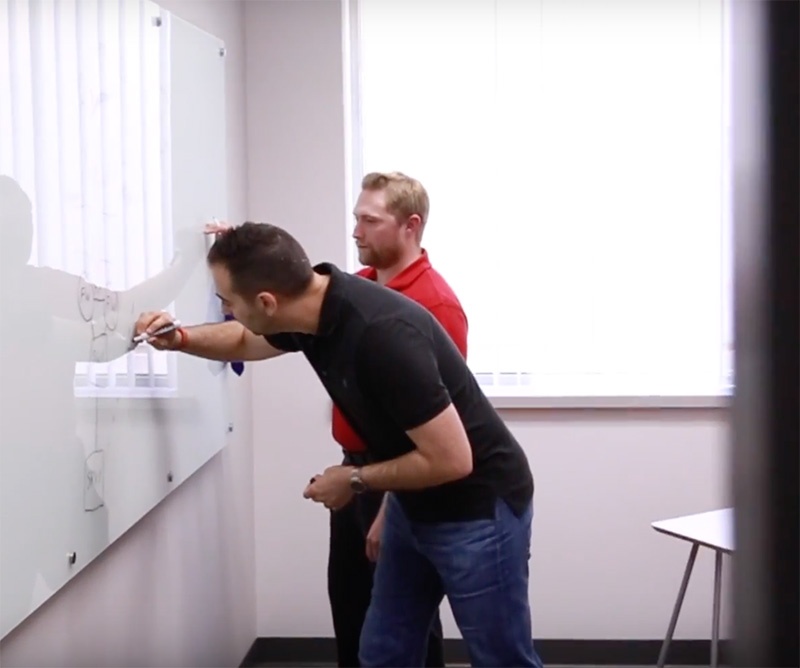 Red Level employees collaborating on a whiteboard